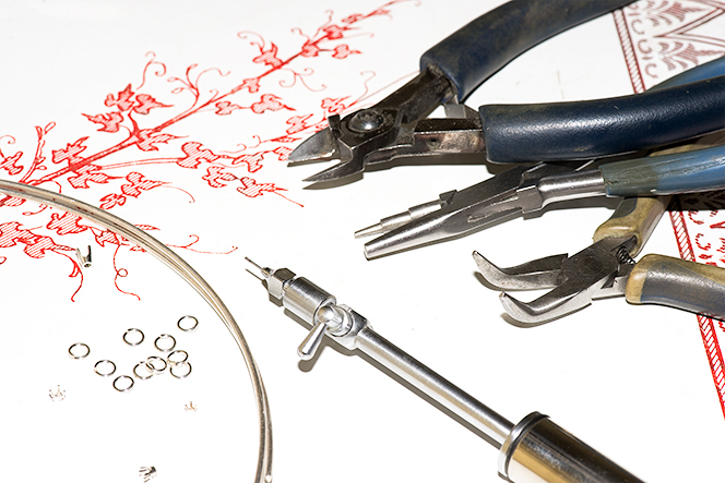 pliers, snips, a torch, sterling silver wire, and findings.