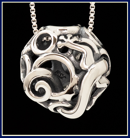 sculptural lizard peaking out of filigree bead in sterling silver