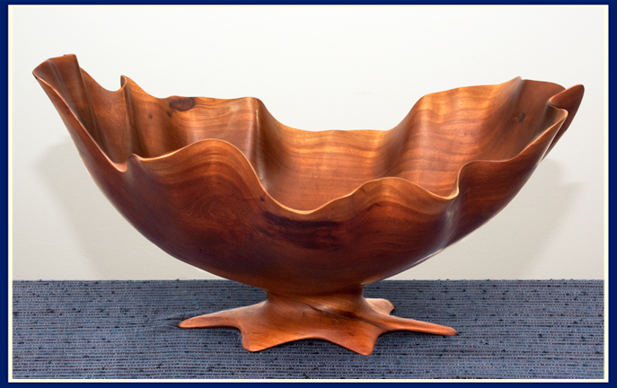 Pedestal style wooden bowl hand carved in cherry with wavy edge