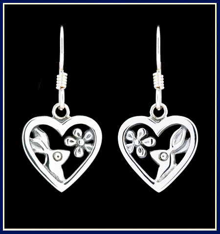 A pair of heart shaped silver earrings with bunnies and flowers