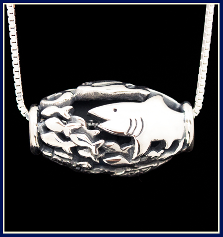 sterling silver bead with a shark chasing fish by Jeni Benos